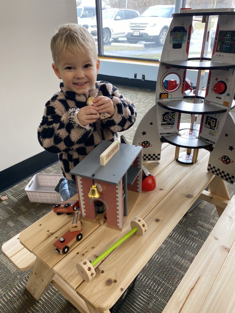 A child playing with industry-leading brand-name toys in the Nugget Square fine motor play area